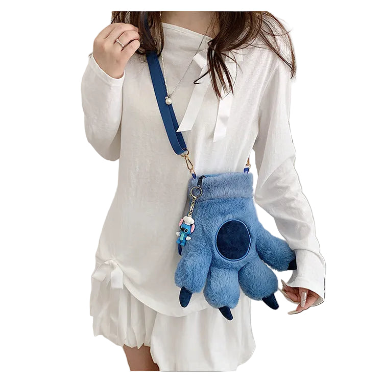 Blue plush backpack with a character charm on a white background