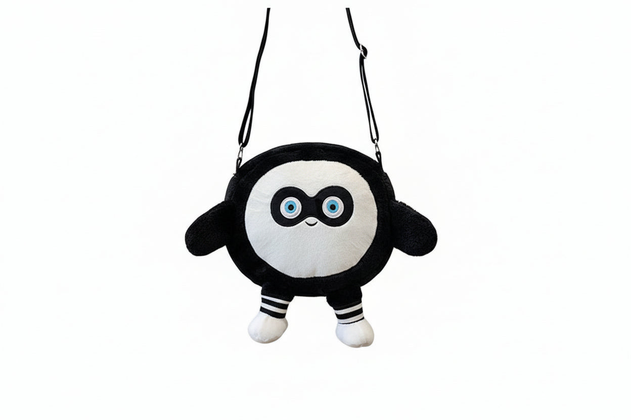 Black and white plush toy with blue eyes on a white background